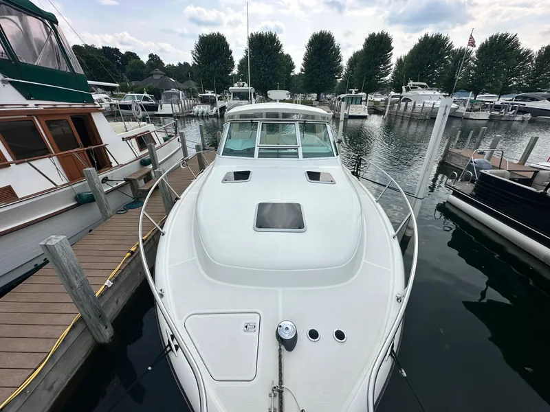 Slide: The Image of 2003 Tiara Yachts 3100 Open docked at marina, surrounded by other boats. - 7