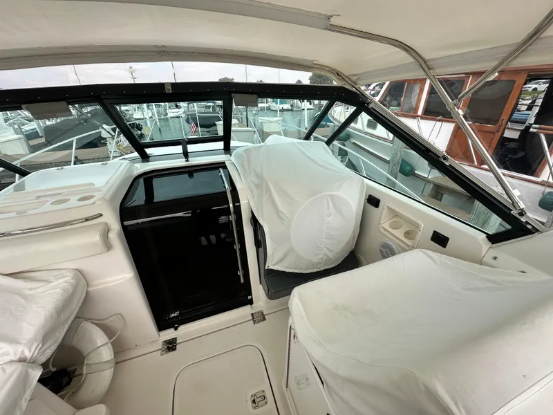 Slide: The Image of 2003 Tiara Yachts 3100 Open cockpit with covered seating and helm, docked at marina. - 9