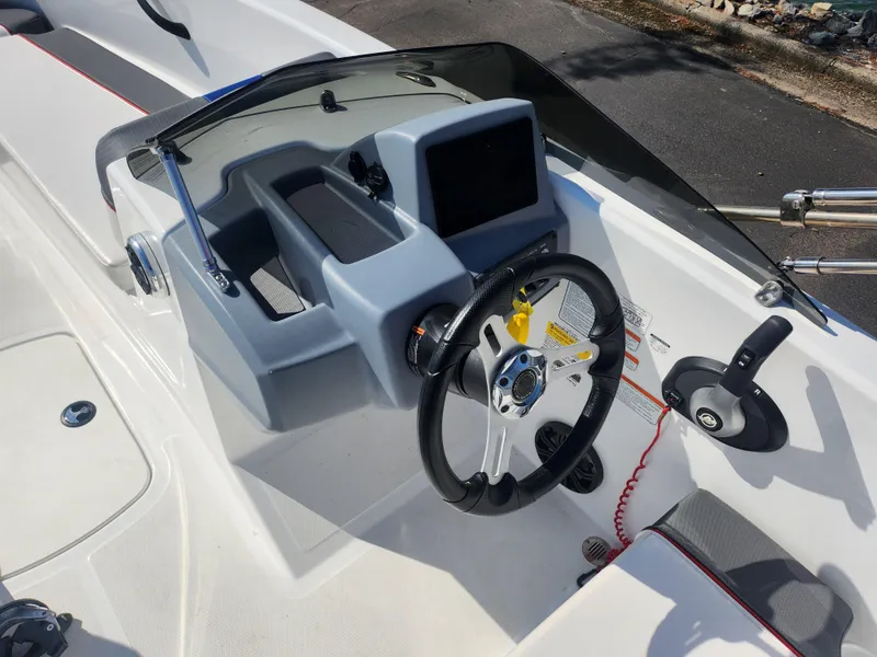 Slide: The Image of 2023 Tahoe T18 boat dashboard with steering wheel and control panel. - 11