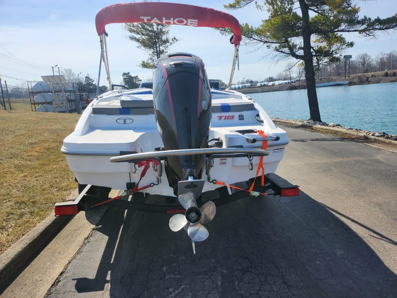 Slide: The Image of 2023 Tahoe T18 boat on trailer by a lakeside road. - 2