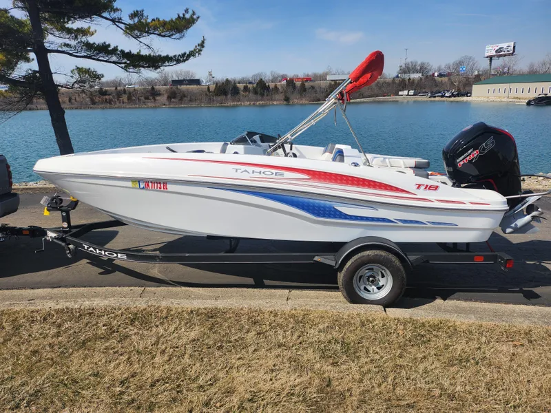 Slide: The Image of 2023 Tahoe T18 boat on trailer by a lake, featuring sleek design and vibrant colors. - 9