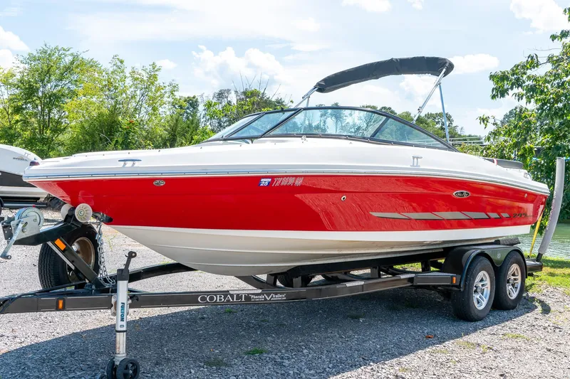 The Image of 2014 Sea Ray 205 Sport boat on trailer, red and white design, parked outdoors. - 1