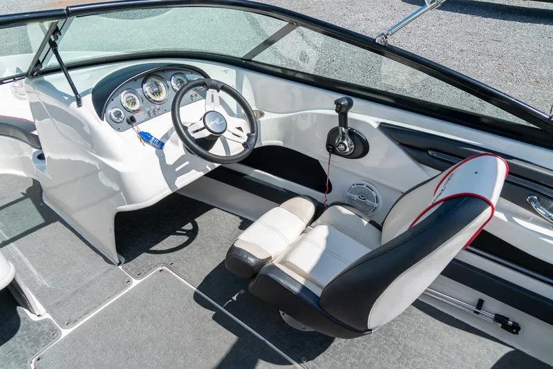 Slide: The Image of 2014 Sea Ray 205 Sport boat interior with steering wheel and dashboard controls. - 14