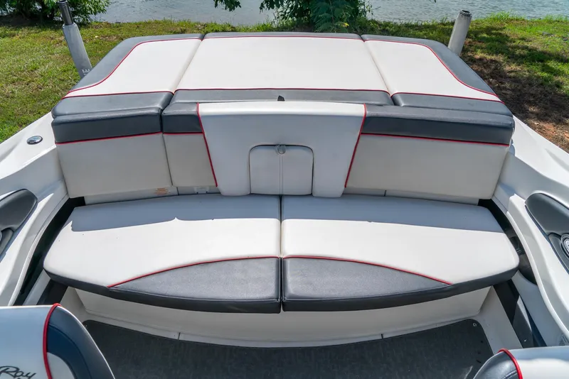 Slide: The Image of 2014 Sea Ray 205 Sport boat interior with cushioned seating and red accents. - 22