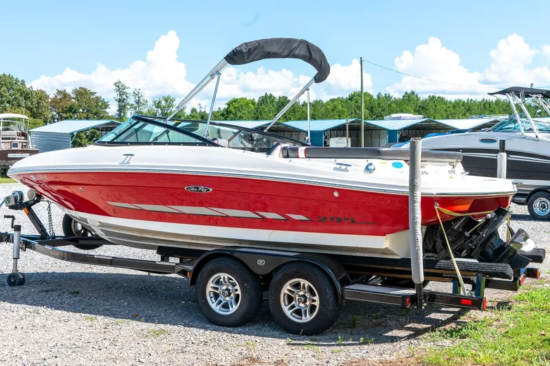 Slide: The Image of 2014 Sea Ray 205 Sport boat on trailer, red and white, parked outdoors. - 3