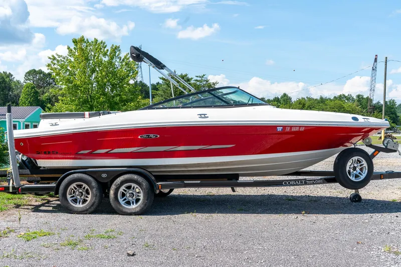 Slide: The Image of 2014 Sea Ray 205 Sport boat on trailer, red and white design, parked outdoors. - 5