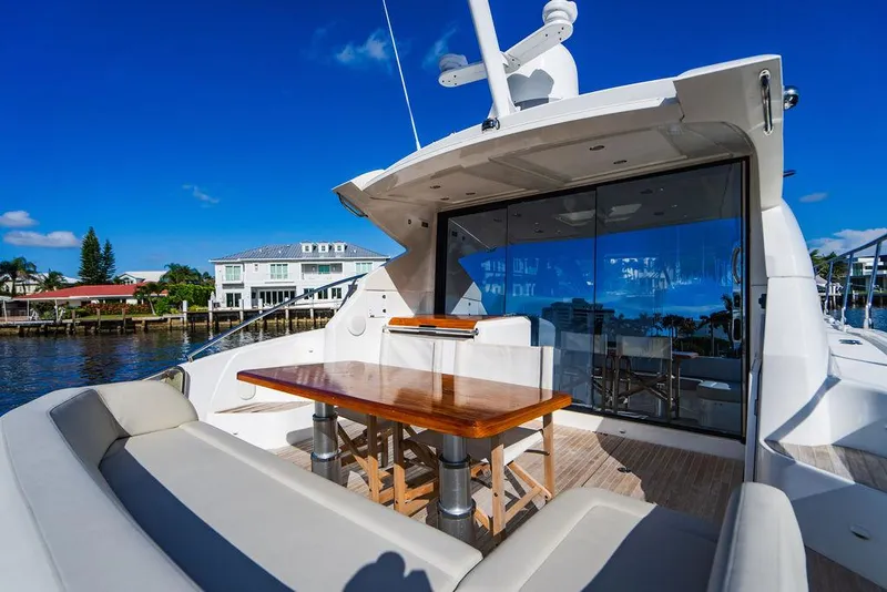 Slide: The Image of 2016 Beneteau Gran Turismo 49 yacht with outdoor seating and table, docked by waterfront homes. - 23