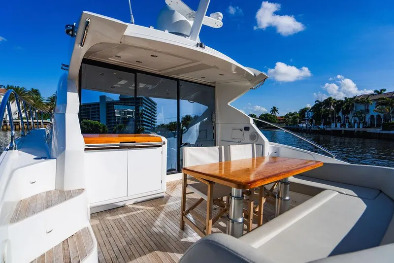 Slide: The Image of 2016 Beneteau Gran Turismo 49 yacht with outdoor seating and table, docked by waterfront. - 24