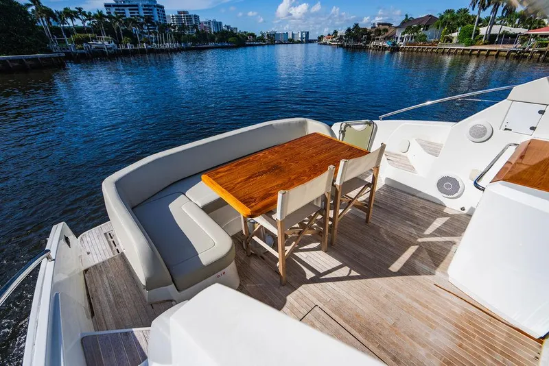 Slide: The Image of Beneteau Gran Turismo 49 yacht deck with seating and table, 2016 model, on a sunny waterway. - 33