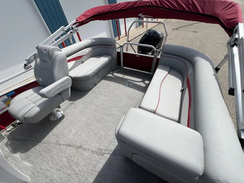 Slide: The Image of 2023 Bennington 20 SVSR pontoon boat interior with gray seating and red canopy. - 20