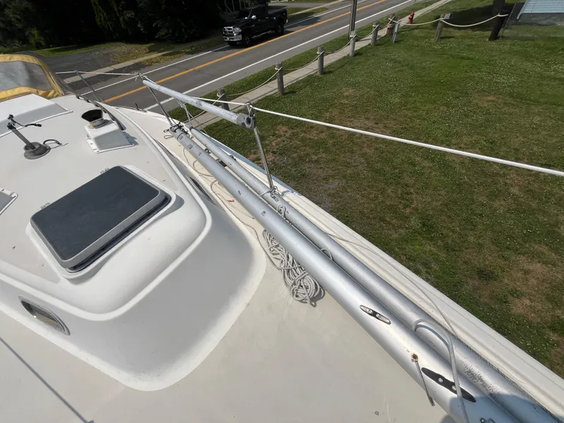 Slide: The Image of Deck of a 1980 Pearson 30 sailboat, featuring mast and road in background. - 17
