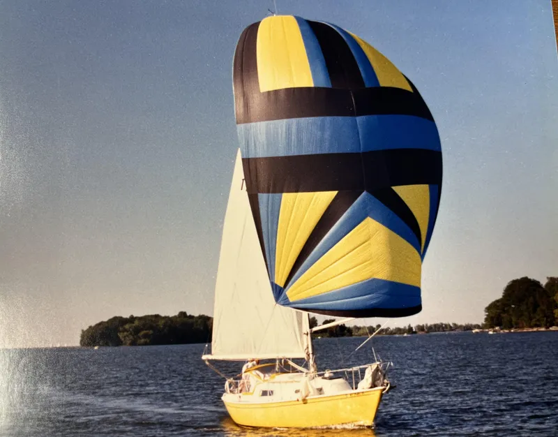 Slide: The Image of 1980 Pearson 30 sailboat with colorful spinnaker on the water. - 3