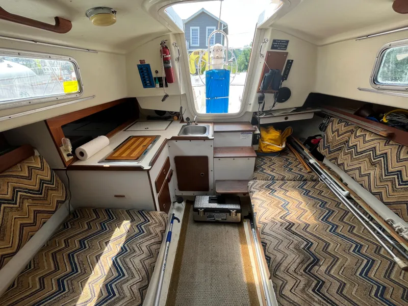 Slide: The Image of Interior of a 1980 Pearson 30 sailboat with cozy seating and kitchenette. - 32