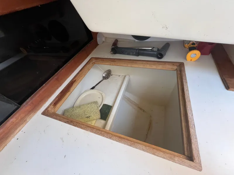 Slide: The Image of Interior of a 1980 Pearson 30 with storage compartment and tools. - 38