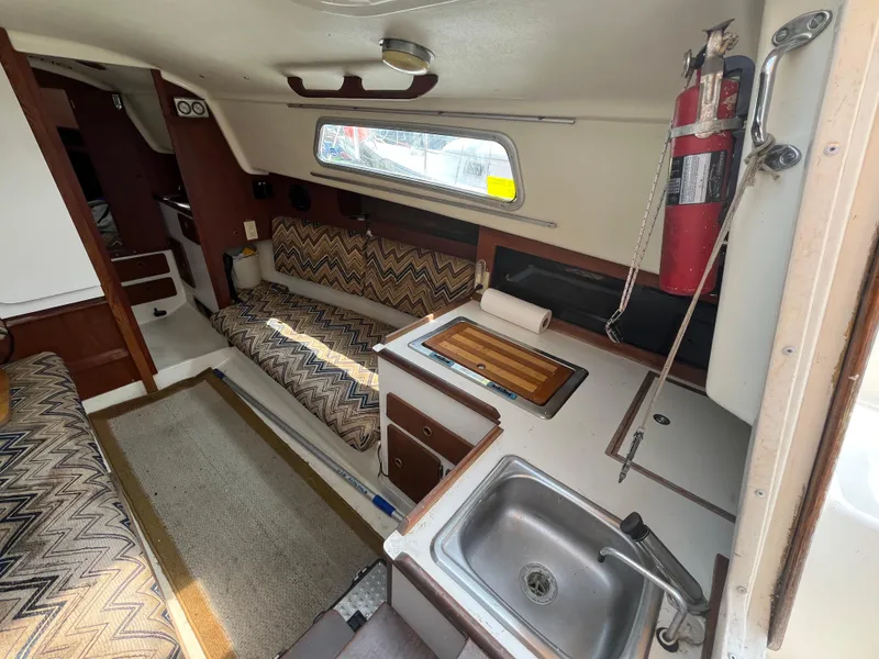 Slide: The Image of Interior of a 1980 Pearson 30 sailboat with kitchen and seating area. - 27