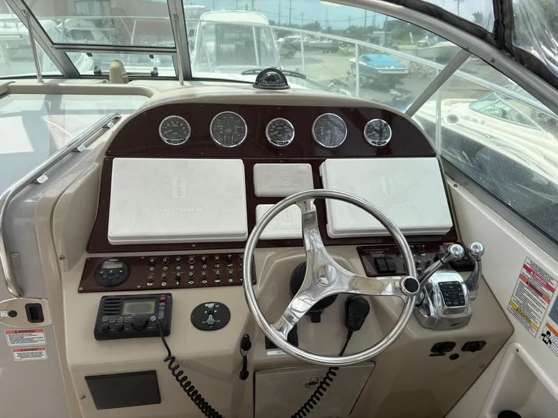 Slide: The Image of 2008 Sea Ray 290 Amberjack helm with steering wheel, gauges, and control panel. - 10