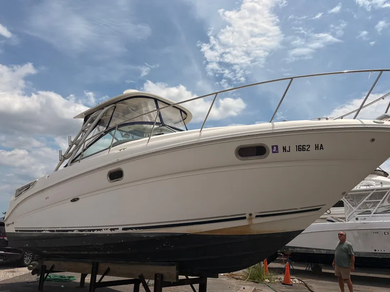 Slide: The Image of 2008 Sea Ray 290 Amberjack boat on dry dock under a partly cloudy sky. - 2
