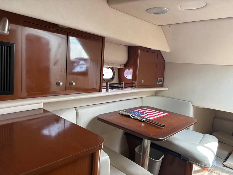 Slide: The Image of 2008 Sea Ray 290 Amberjack cabin interior with wooden cabinets and dining area. - 21