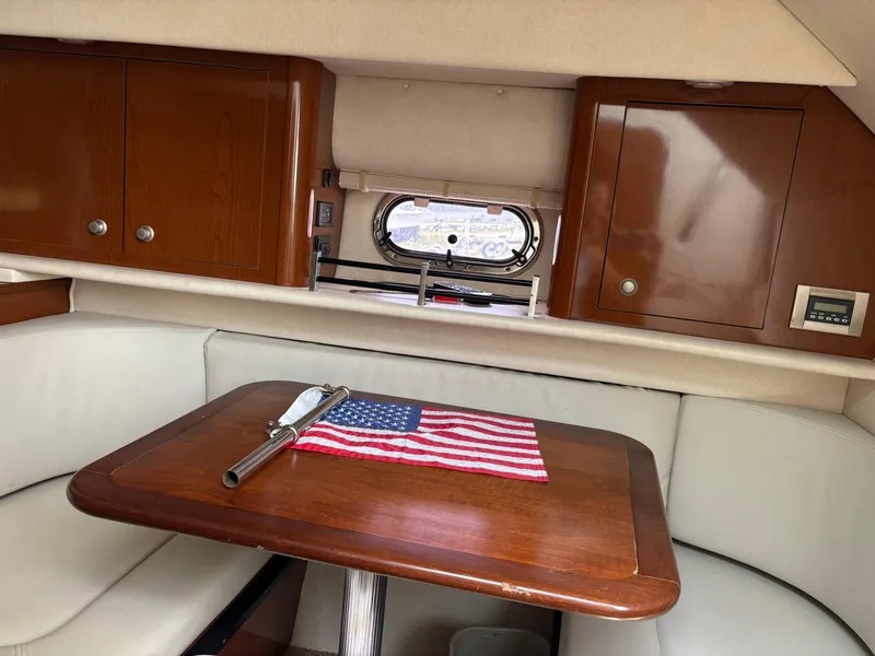 Slide: The Image of Interior of 2008 Sea Ray 290 Amberjack with wooden table and American flag decor. - 22