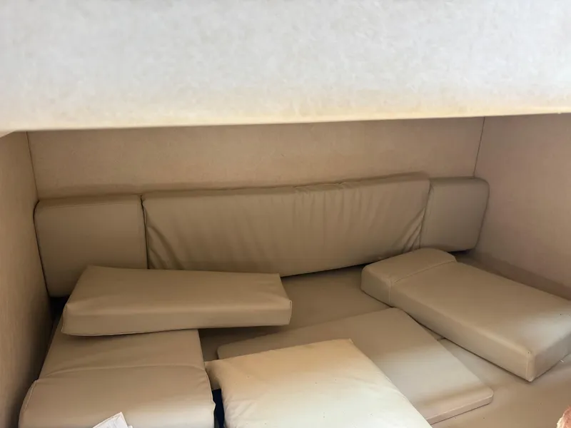 Slide: The Image of 2008 Sea Ray 290 Amberjack cabin interior with beige cushions and seating area. - 27