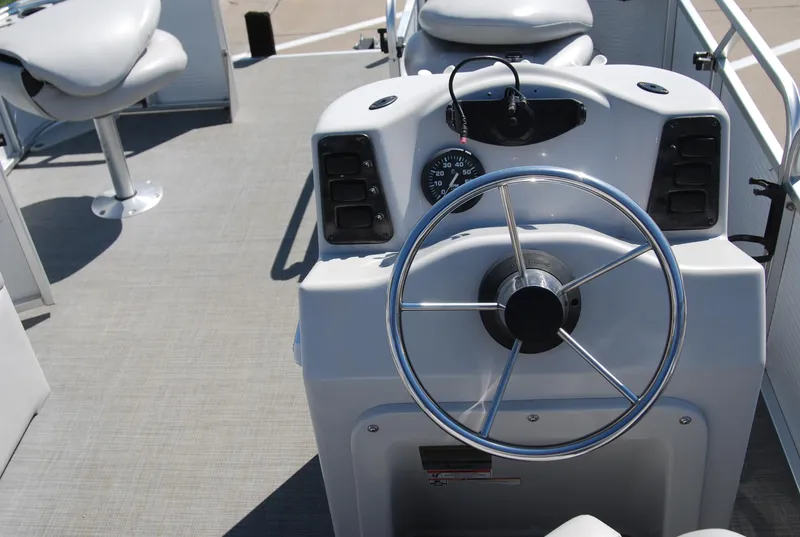 Slide: The Image of 2016 Apex Marine QUEST 7516 boat steering console with chrome wheel and dashboard controls. - 7