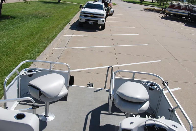 Slide: The Image of 2016 Apex Marine QUEST 7516 pontoon boat parked near a white truck. - 9