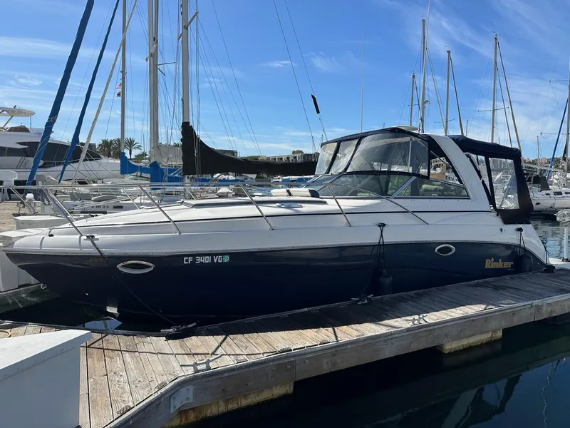 The Image of 2004 Rinker Fiesta Vee 312 boat docked at marina under clear blue sky. - 0