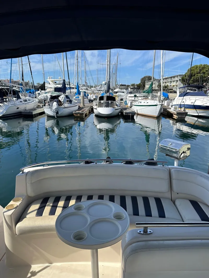 Slide: The Image of 2004 Rinker Fiesta Vee 312 in marina, surrounded by sailboats and calm water. - 10