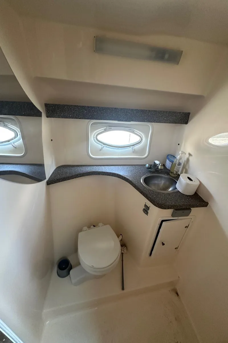 Slide: The Image of 2004 Rinker Fiesta Vee 312 boat bathroom with sink, toilet, and window. - 13