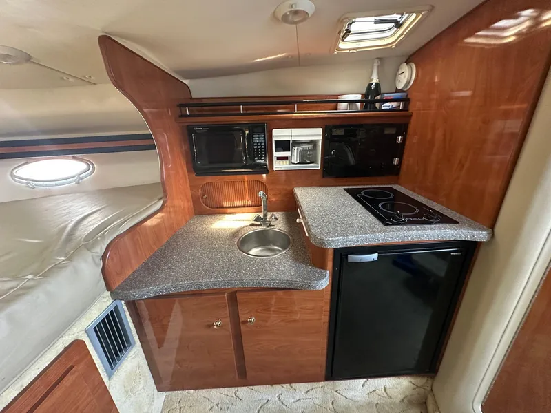 Slide: The Image of 2004 Rinker Fiesta Vee 312 cabin kitchen with sink, microwave, and stove. - 15