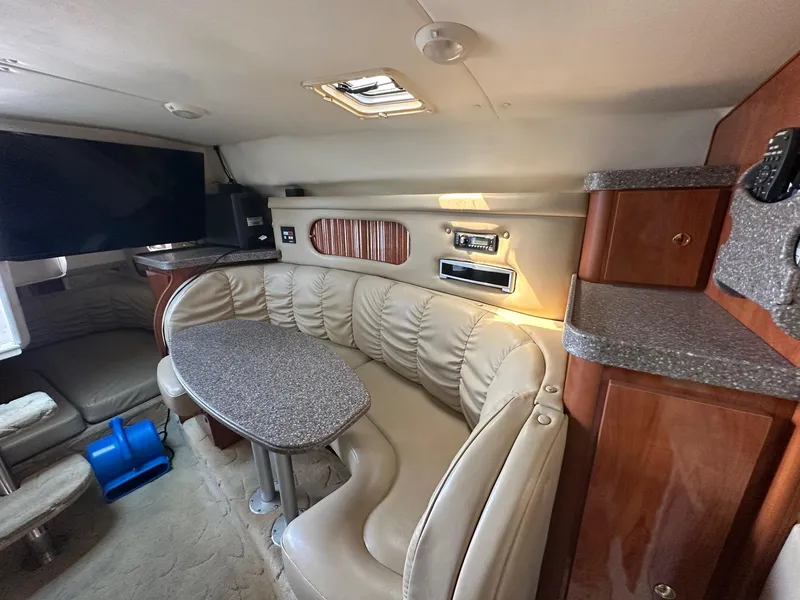 Slide: The Image of 2004 Rinker Fiesta Vee 312 cabin interior with seating, table, and entertainment system. - 16