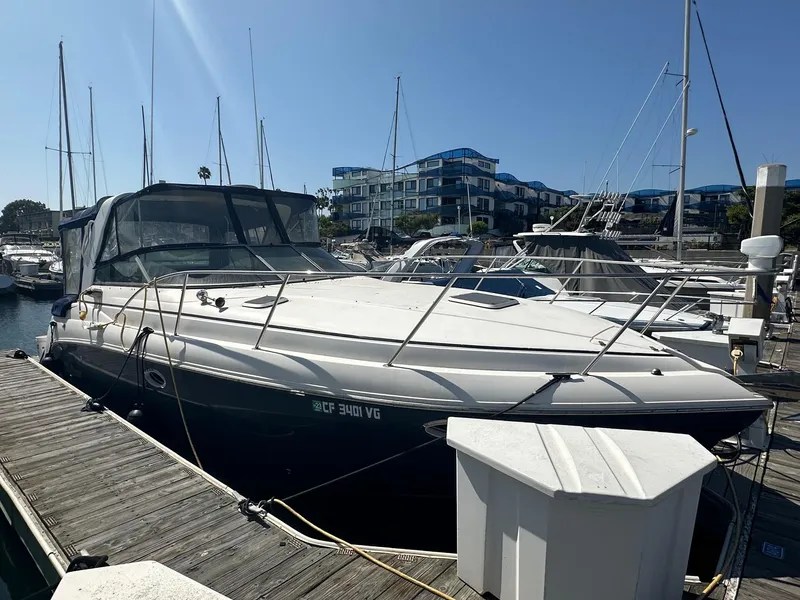 Slide: The Image of 2004 Rinker Fiesta Vee 312 docked at marina under clear blue sky. - 2