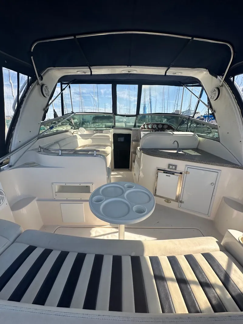 Slide: The Image of 2004 Rinker Fiesta Vee 312 boat interior with seating, table, and dashboard view. - 5