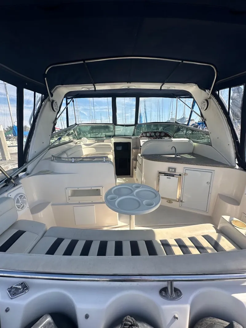 Slide: The Image of 2004 Rinker Fiesta Vee 312 boat interior with seating, table, and helm. - 6