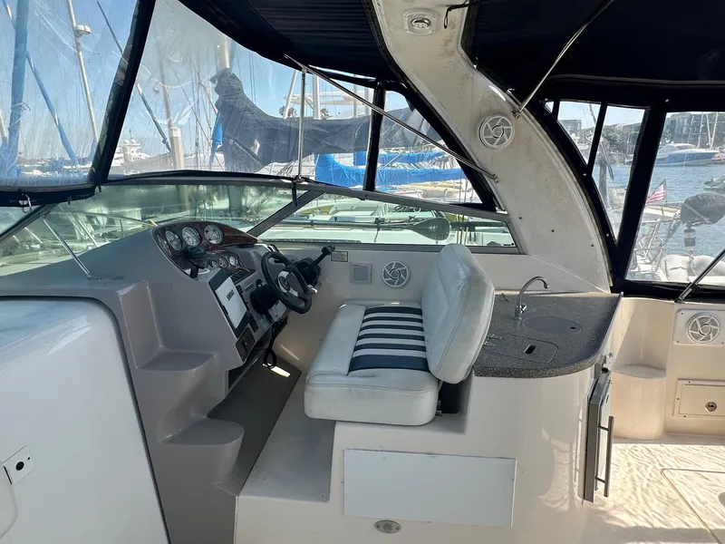 Slide: The Image of 2004 Rinker Fiesta Vee 312 boat cockpit with steering wheel and seating area. - 7