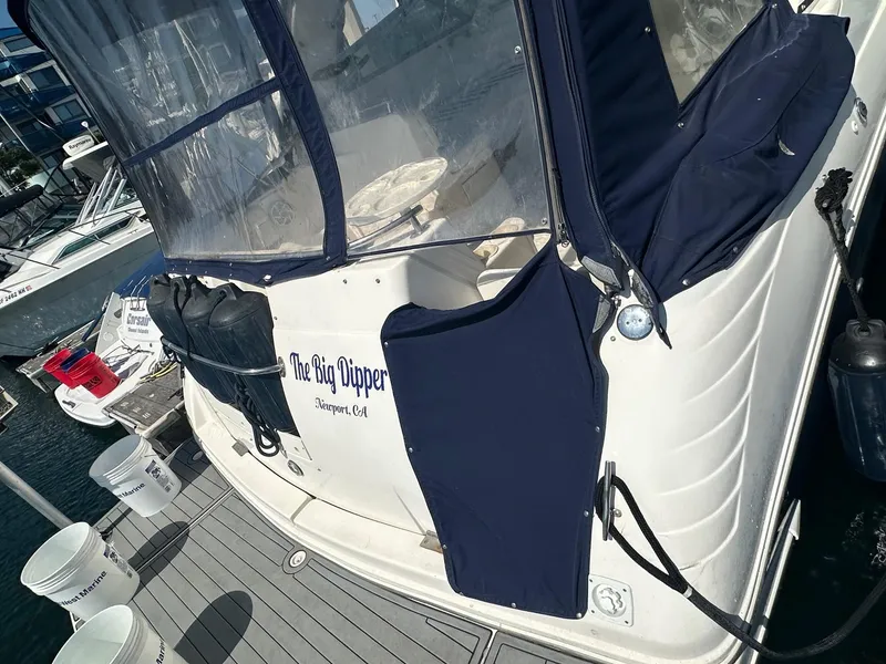 Slide: The Image of 2004 Rinker Fiesta Vee 312 boat docked, featuring navy covers and "The Big Dipper" name. - 8