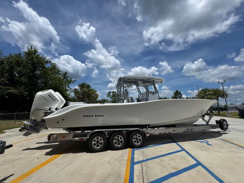 Slide: The Image of 2026 Cape Horn 34 XS boat on trailer under a partly cloudy sky. - 12
