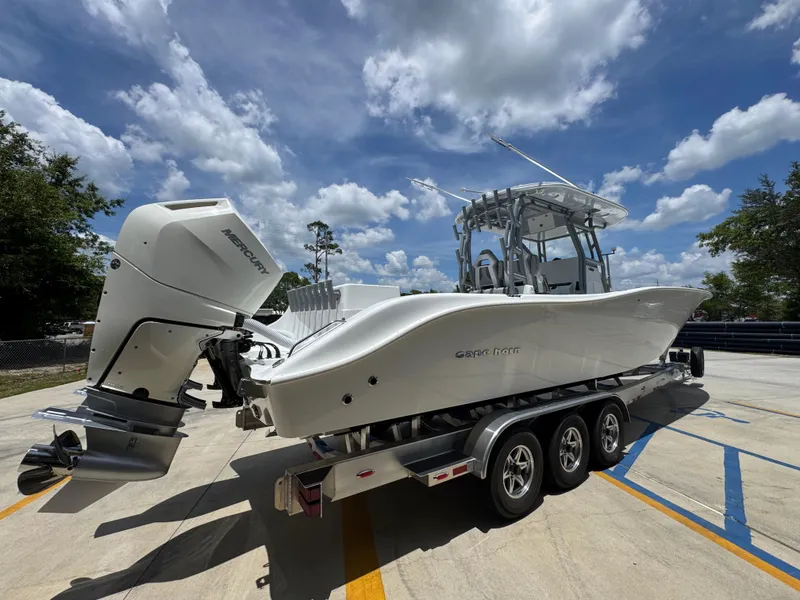 Slide: The Image of 2026 Cape Horn 34 XS boat on trailer, featuring Mercury outboard engines, under a partly cloudy sky. - 13