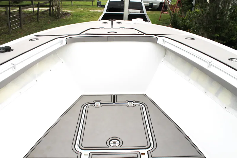 Slide: The Image of 2005 Yellowfin 31 Open boat with dual outboard engines, parked on grass. - 11