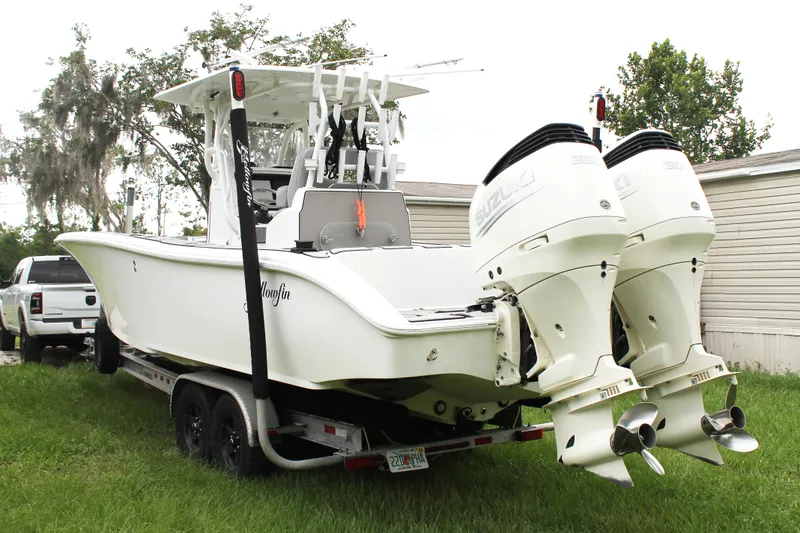 Slide: The Image of 2005 Yellowfin 31 Center Console boat on calm water near a bridge. - 2