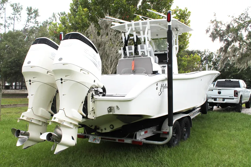 Slide: The Image of 2005 Yellowfin 31 Center Console boat cruising on calm waters near a bridge. - 4