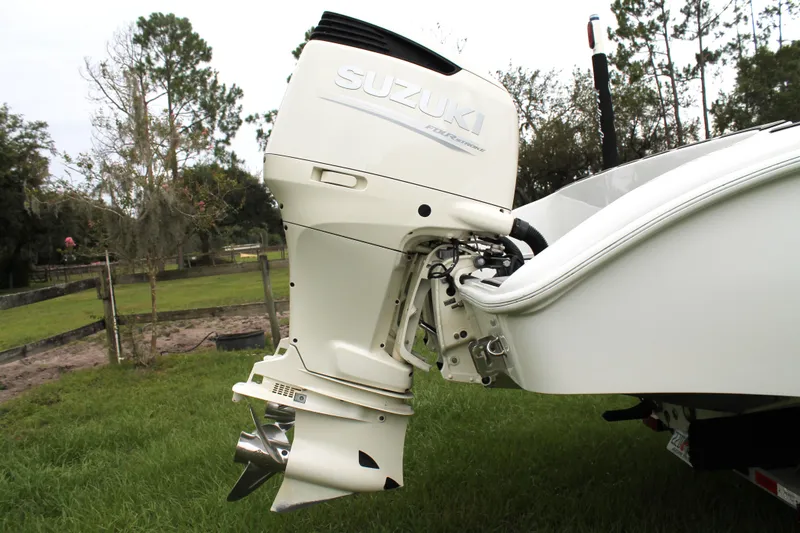 Slide: The Image of 2005 Yellowfin 31 Center Console boat on calm water, with fishing rods and cityscape background. - 5