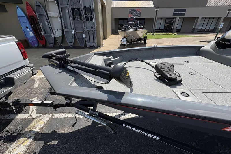Slide: The Image of 2016 Tracker Pro Team 175 TF boat on trailer, parked near kayaks. - 4