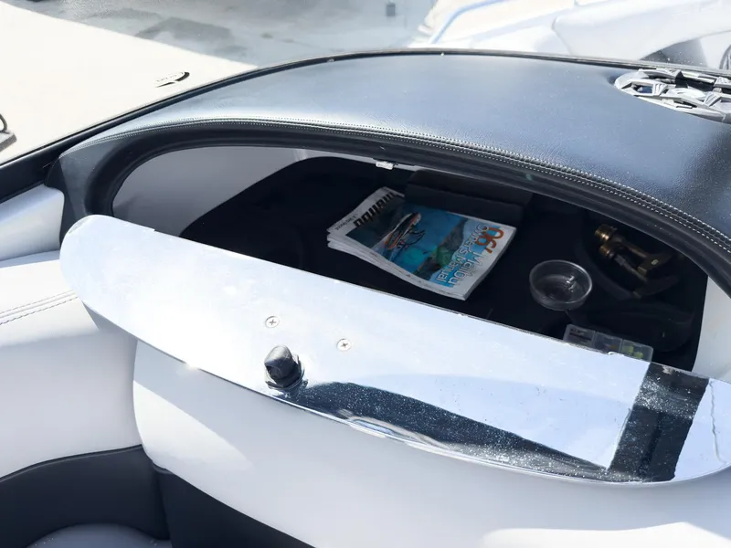 Slide: The Image of Open glove compartment in 2006 Malibu 23 VLX boat with magazines and accessories. - 11