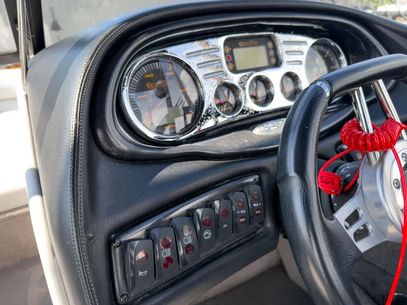 Slide: The Image of Dashboard of a 2006 Malibu 23 VLX boat with gauges and control switches. - 15