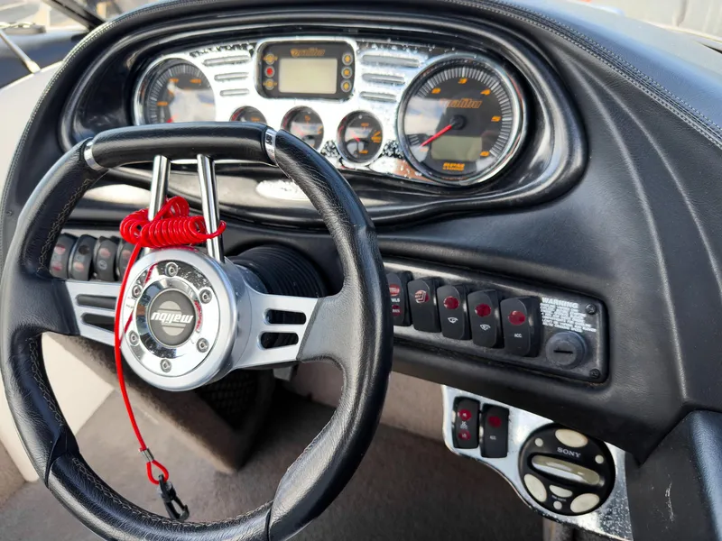 Slide: The Image of Dashboard of a 2006 Malibu 23 VLX boat with steering wheel and control panel. - 16