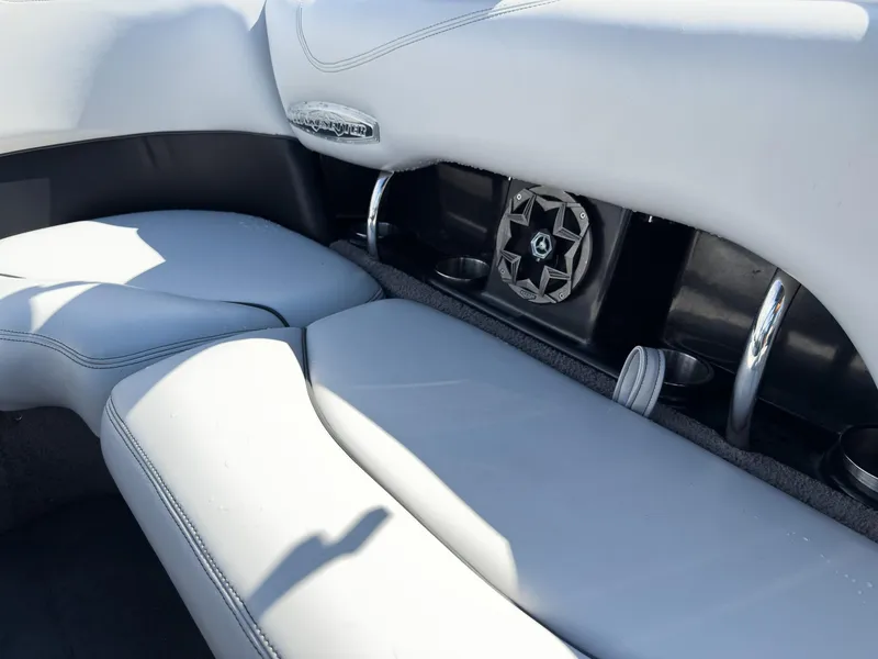 Slide: The Image of 2006 Malibu 23 VLX boat interior with white seating and built-in speaker system. - 17