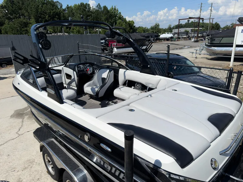 Slide: The Image of 2006 Malibu 23 VLX boat with sleek design and spacious seating on a trailer. - 3