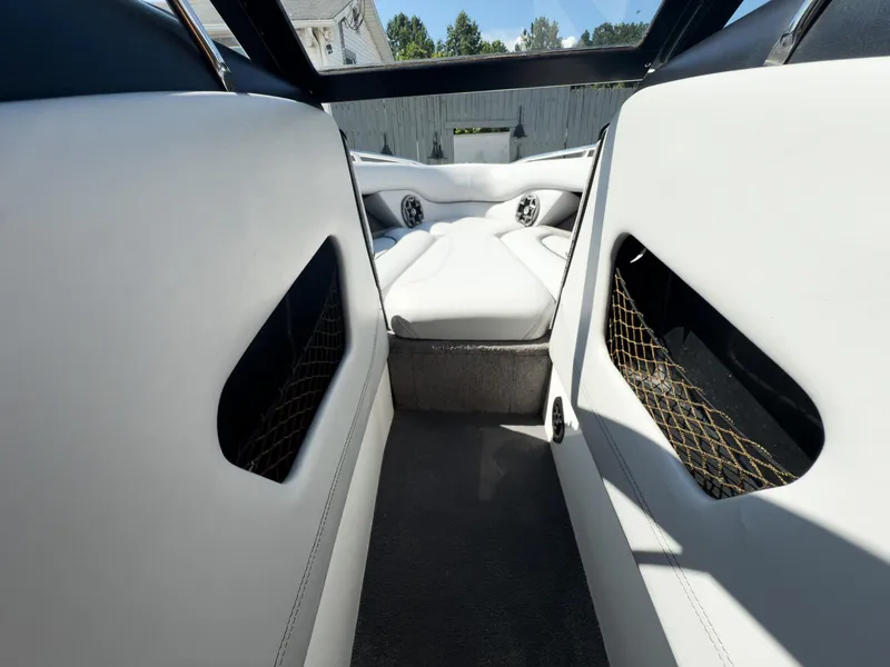 Slide: The Image of Interior of a 2006 Malibu 23 VLX boat with white seating and storage compartments. - 6