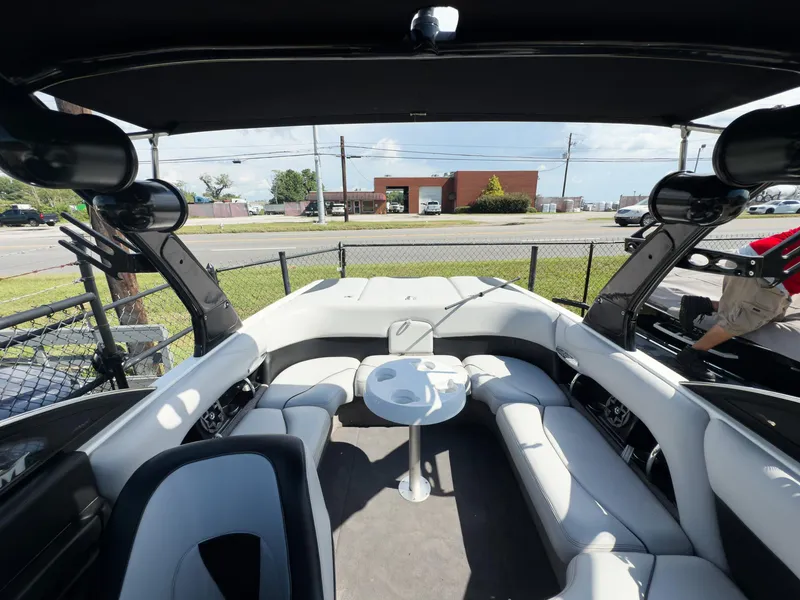 Slide: The Image of Interior of a 2006 Malibu 23 VLX boat with white seating and a small table. - 7